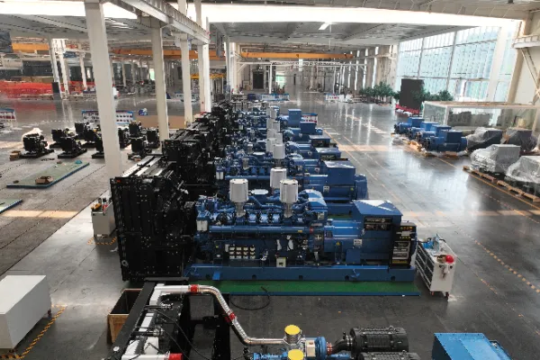 Large industrial diesel generator set in soundproof enclosure at manufacturing facility